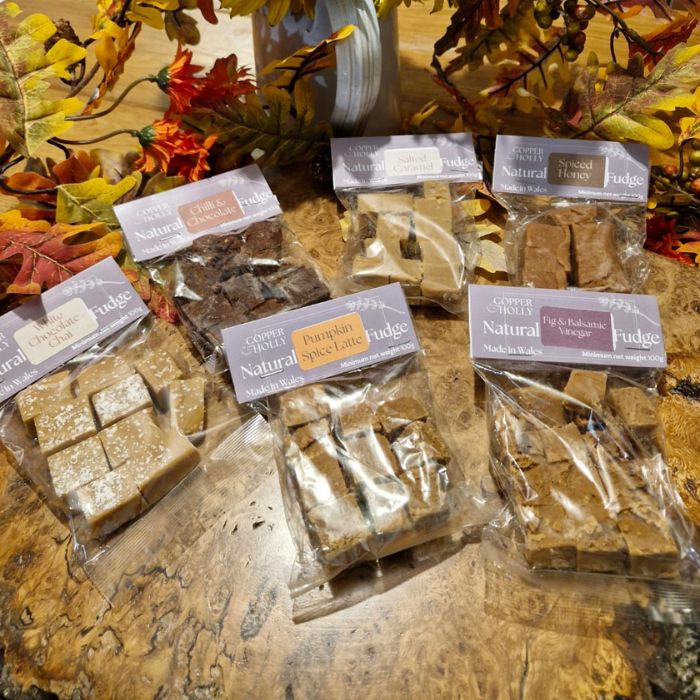 Packages of fudge with visible brand name on a wooden surface with autumn leaves.