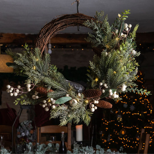 half vine wreath with foliage and berries against a xmas background