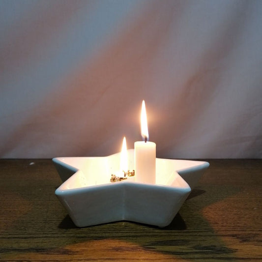 Picture of one of the ivory fragrance-free wax dinner candles burning with a bright still flame