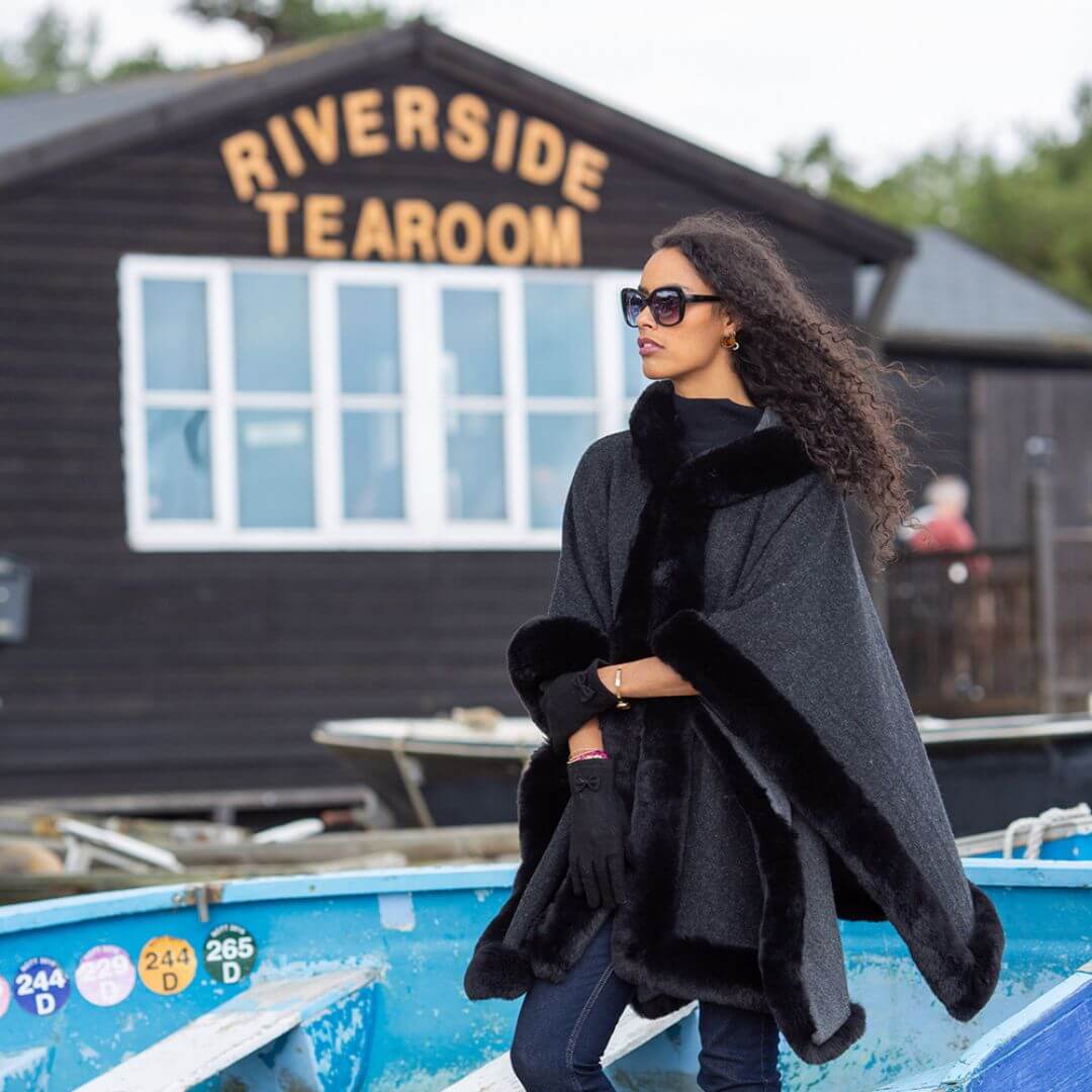 Black faux fur lined poncho with hood in river location