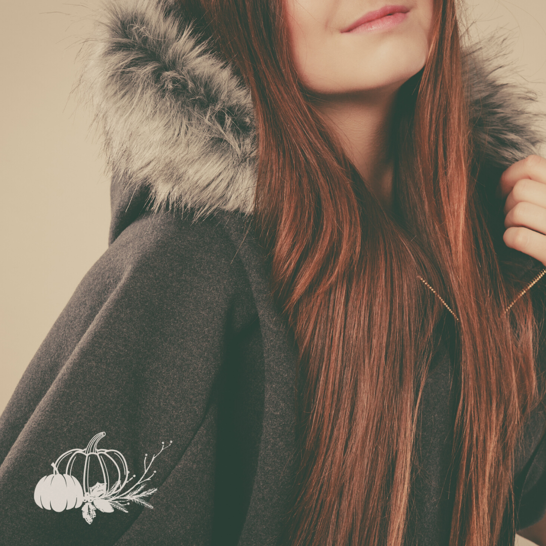 Woman with long hair wearing a poncho with faux fur lining the edge