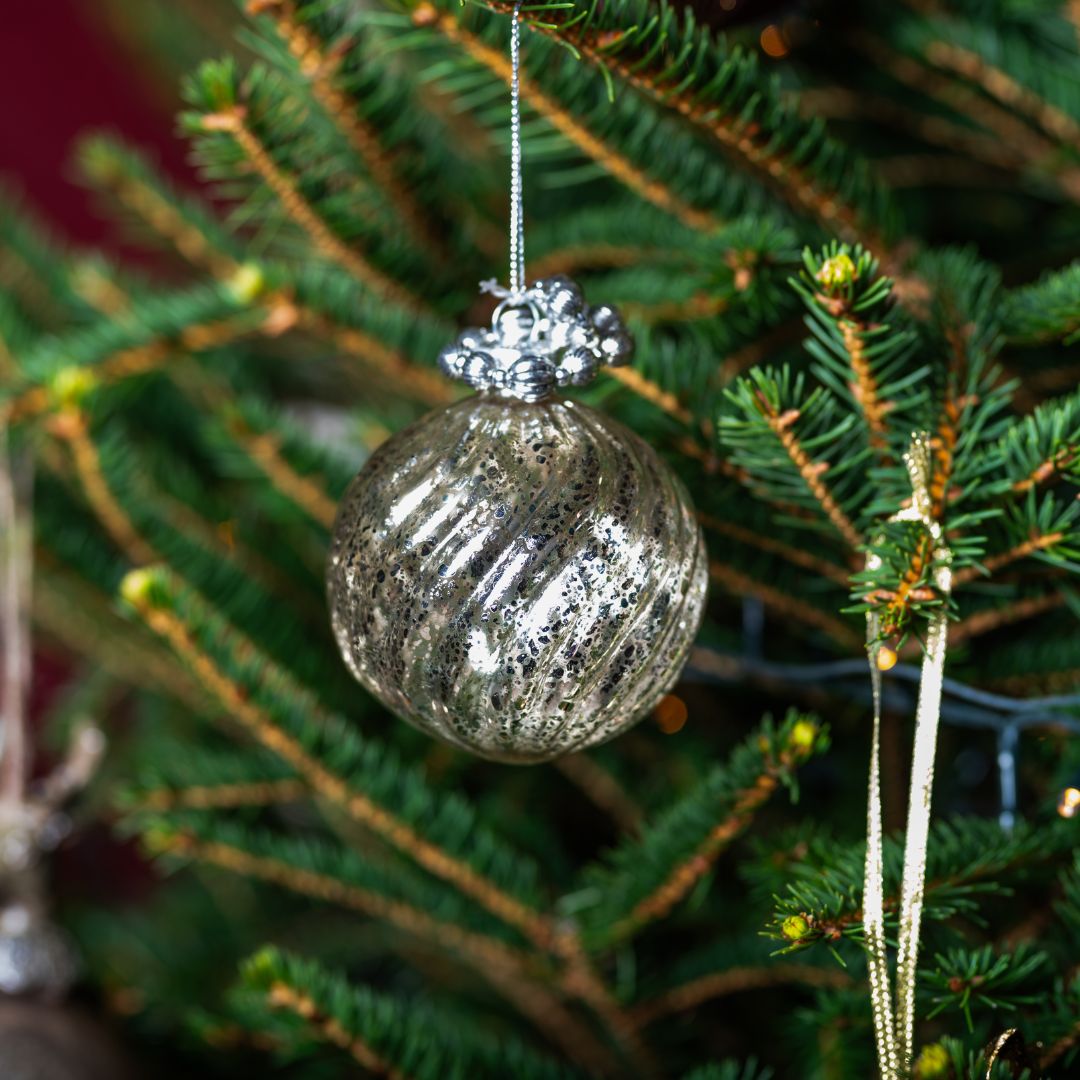 Decorative glass ornament hanging on a Christmas tree branch