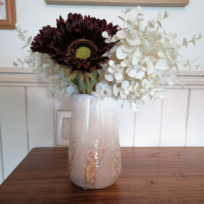 Decorative vase with flowers on a wooden surface