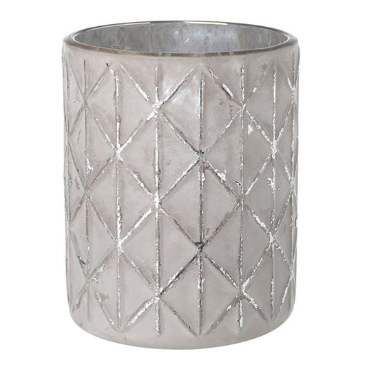 Decorative glass votive candle holder with geometric pattern on a white background