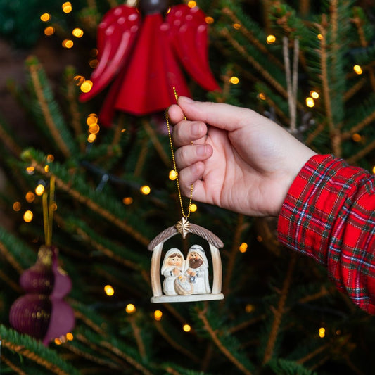 Nativity tree decoration against a Christmas tree