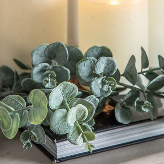 Faux eucalyptus leaves on a book with a blurred background