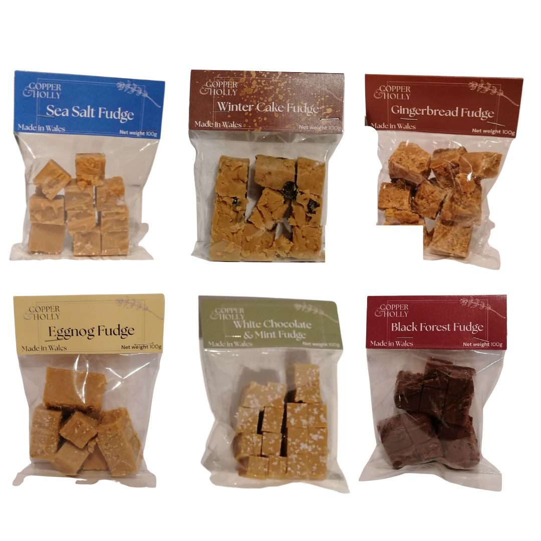 Six packages of Copper & Holly fudge in Christmas flavours on a white background