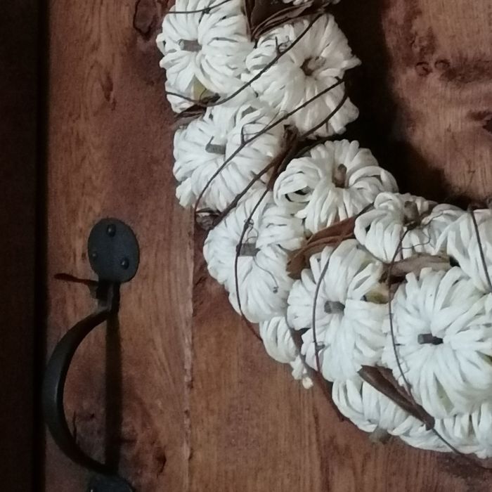 White pumpkin wreath with natural  accents on an oak door