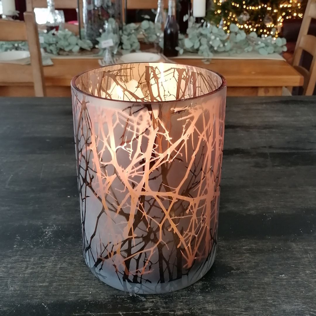 Copper hurricane lantern showing the inside of the vase with candles lit
