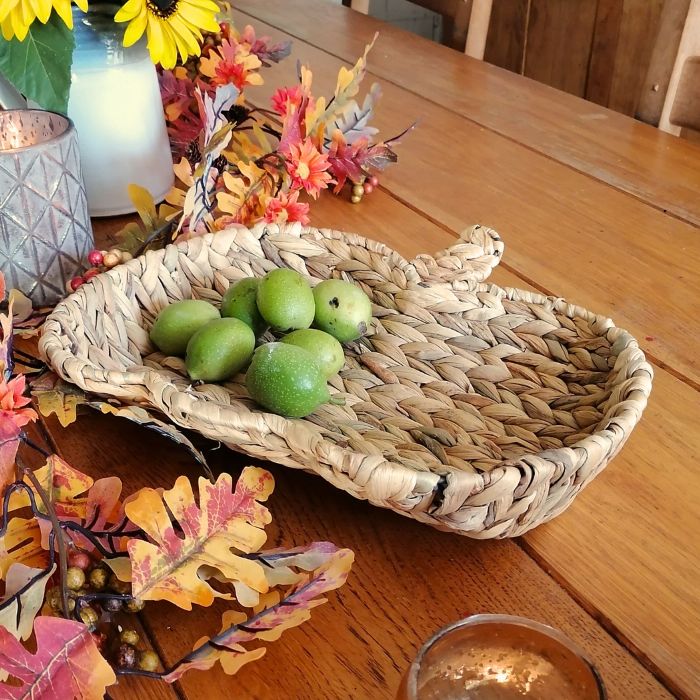 Woven basket with green walnuts on a wooden table with decorative elements
