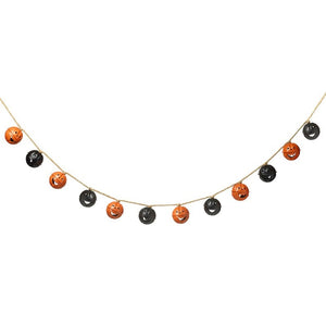 Alternating black and orange bells carved to look like jac-o-lanterns threaded along string for this halloween garland