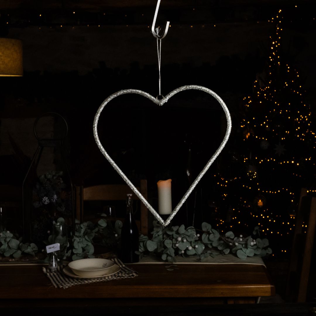A large hanging clear bead heart with a festive dark background