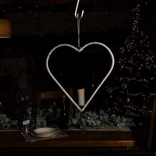 A large hanging clear bead heart with a festive dark background