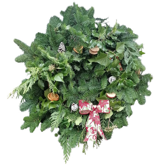 Christmas wreath with greenery, pinecones, and a decorative bow on a white background