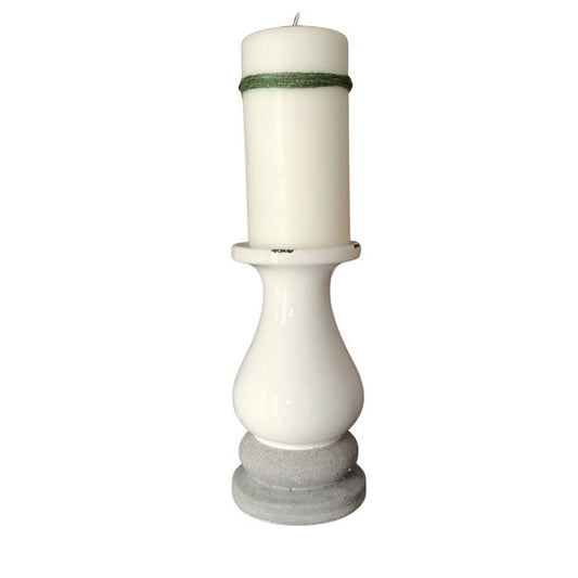 White candle in a decorative holder with a gray base on a white background