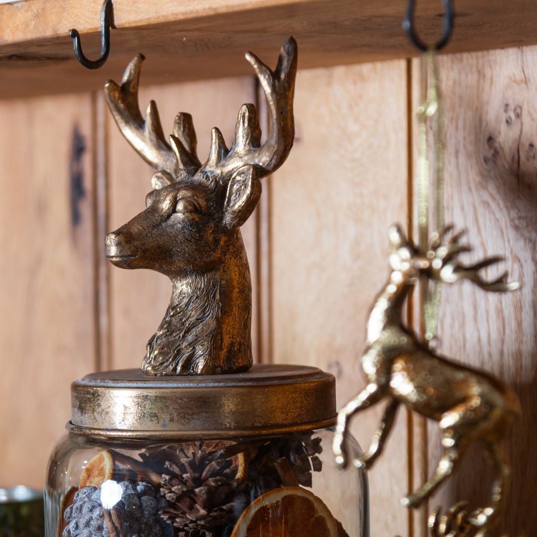 Decorative deer head on a jar with a wooden background
