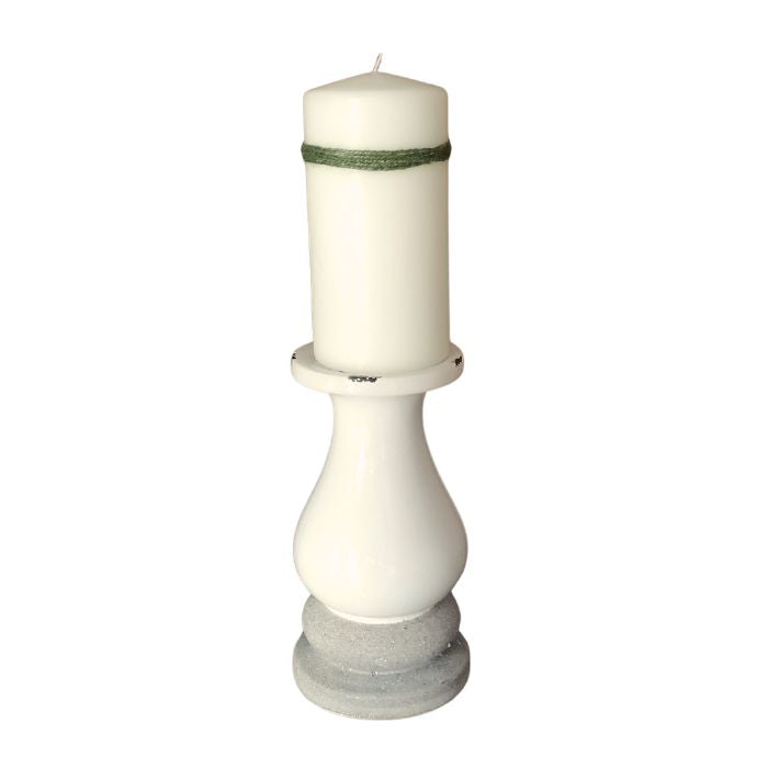White candle in a decorative holder on a white background