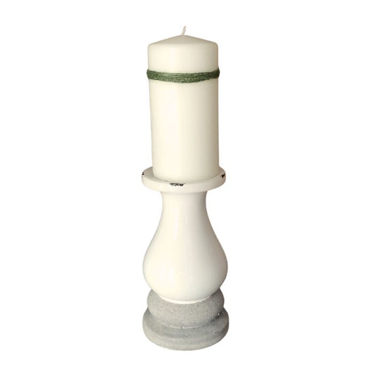 White candle in a decorative holder on a white background