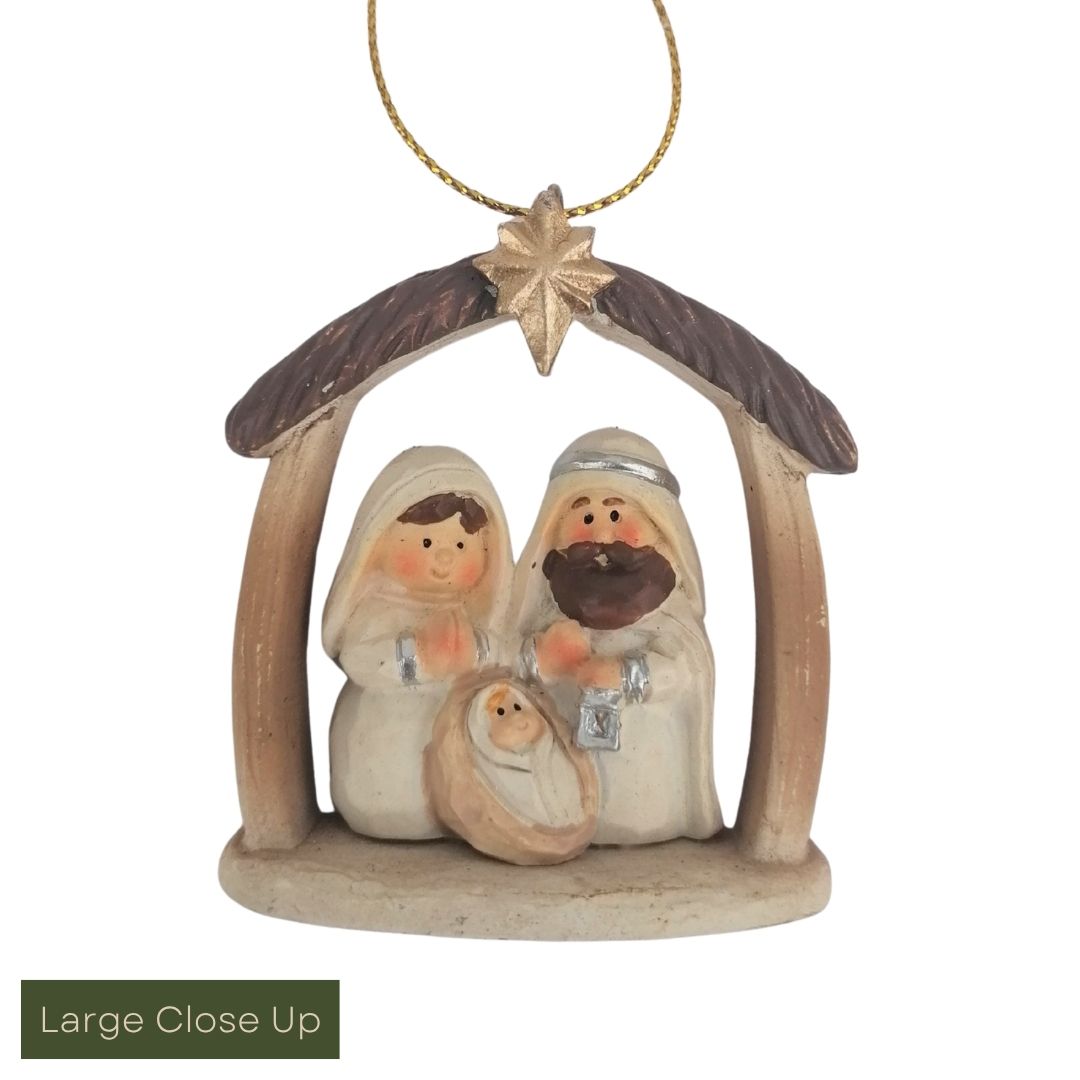 Decorative nativity scene ornament with stable, star, and figures on a white background