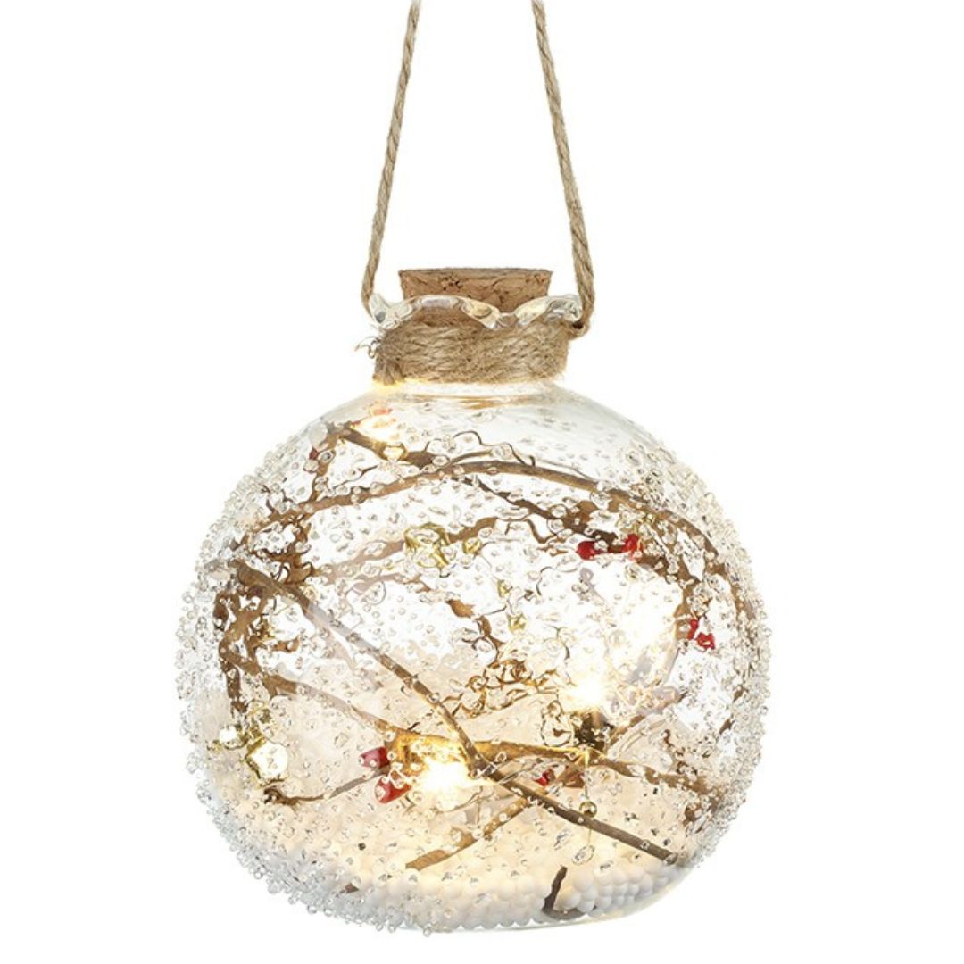 Decorative glass ball with LED lights and twigs on a white background