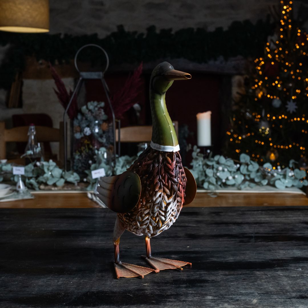 Decorative duck figure on a dark surface with a festive background