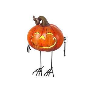 Shorter orange metal pumpkin with wire legs dangling at the side and bird like legs.  this metal pumpkin shows the LED light on
