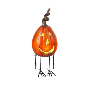 Taller metal pumpkin design with LED light on.  Arms are dangling at hte side of this slimmer squash like carved pumpkin with a a happy face.  Long bird like legs complete the look