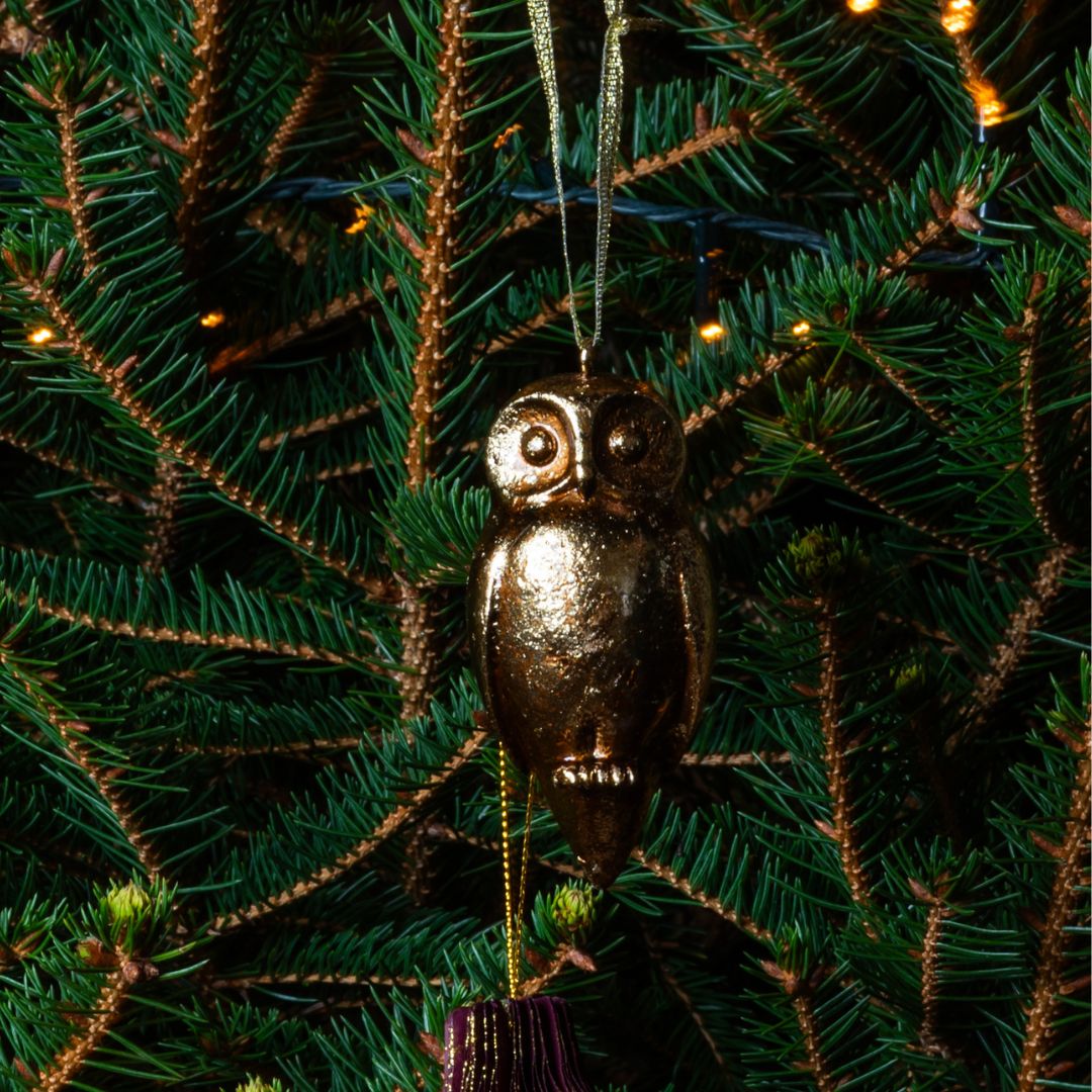 Gold owl ornament on a decorated Christmas tree