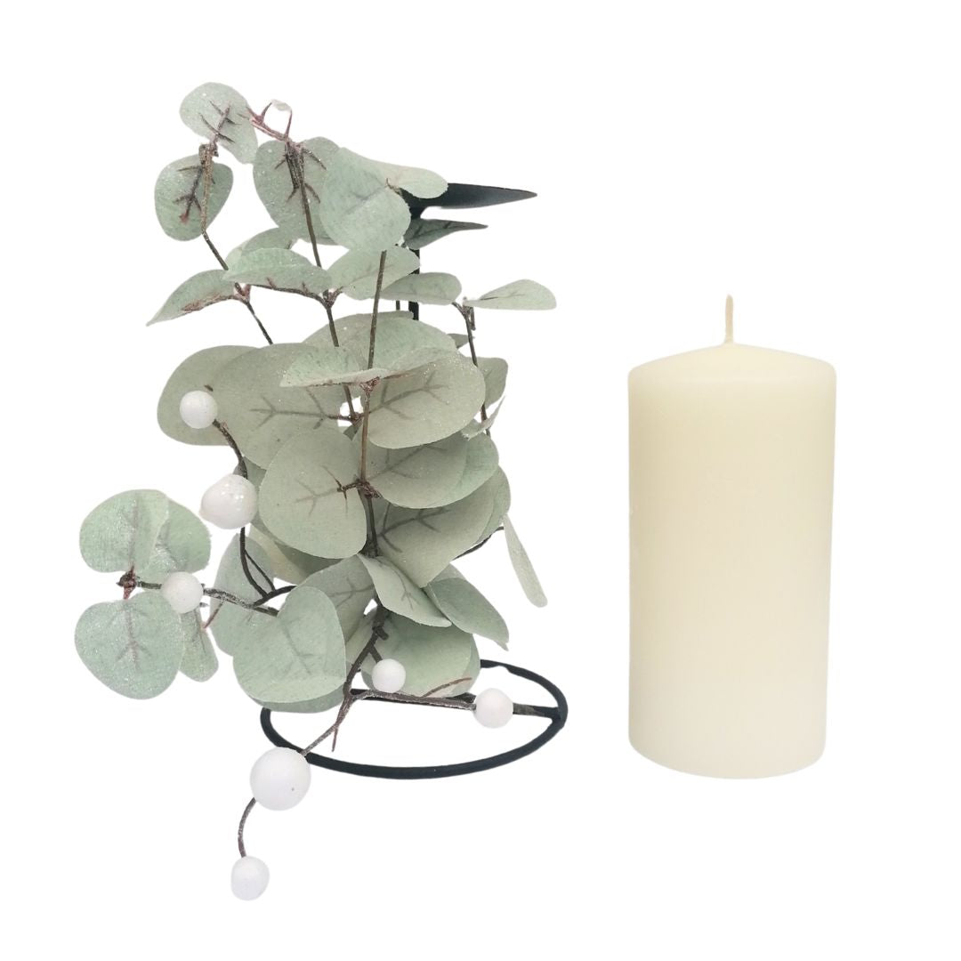 Decorative eucalyptus branch with white berries and a white candle on a white background