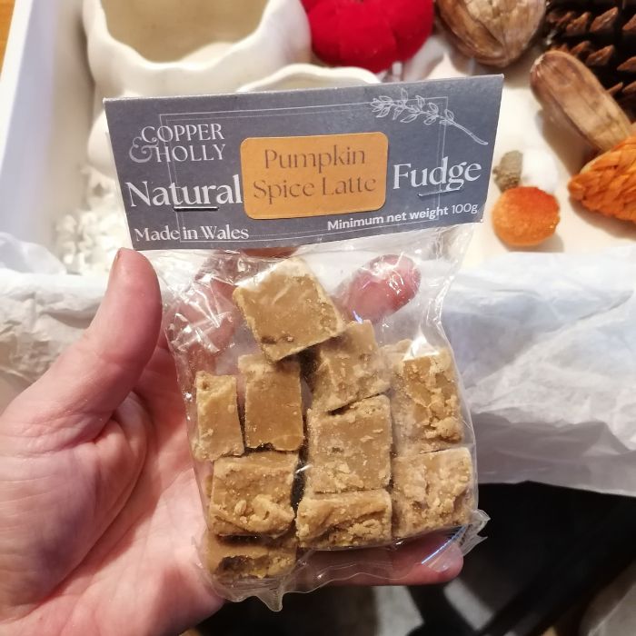 Packaged pumpkin spice latte fudge with a visible label held by a hand.