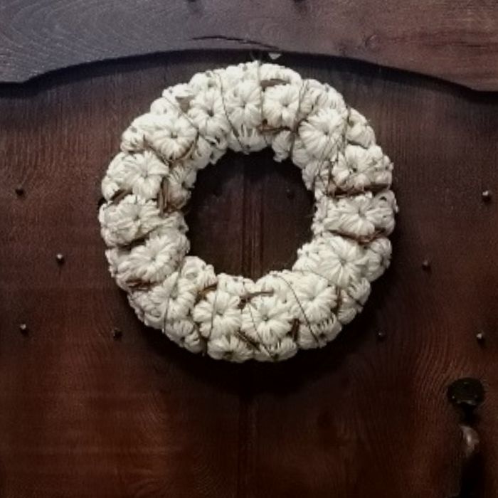 White pumpkin wreath on a wooden door