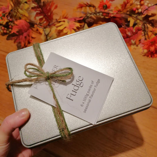 Silver fudge box with a bow and 'Fudge' label against a floral background
