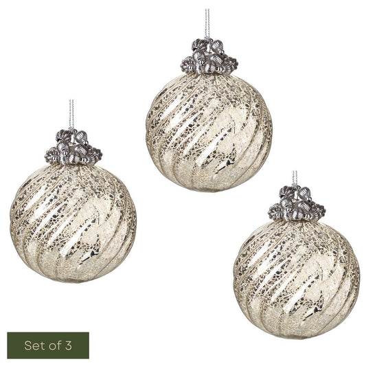 Set of three silver glass ornaments with textured finish on a white background