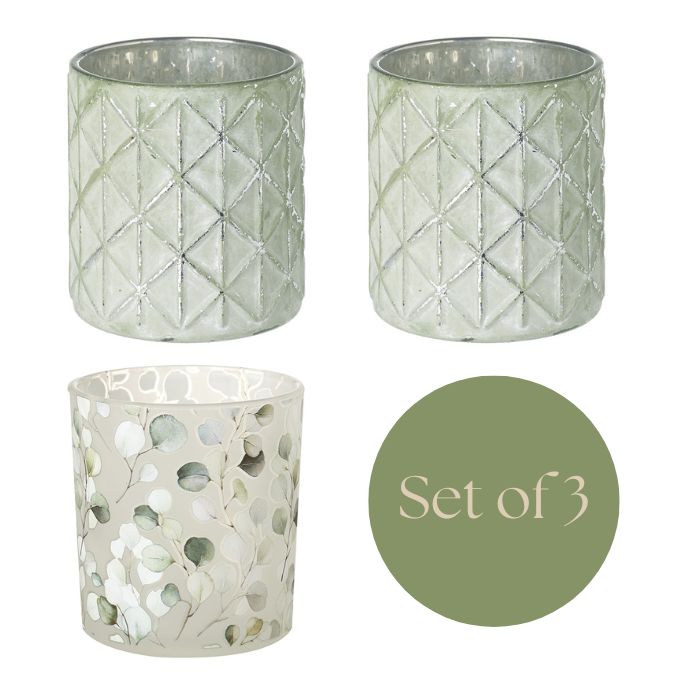 Three decorative candle holders with geometric and natural patterns on a white background.