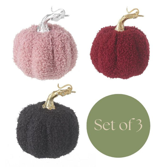 Set of three textured pumpkins in pink, red, and black with gold stems on a white background.