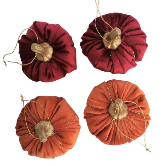 Four fabric pumpkins in red and orange showing the tops and gold stems on a white background
