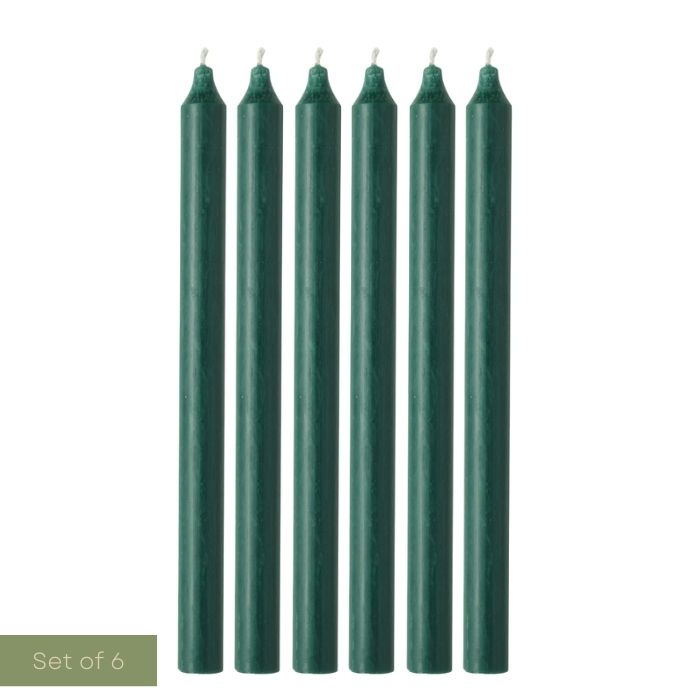 Set of six green candles on a white background