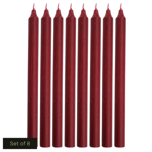 White cut out product image showing a line of 8 burgundy, fragrance-free wax dinner candles