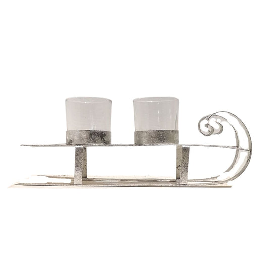 Decorative metal sleigh with two candle holders on a white background