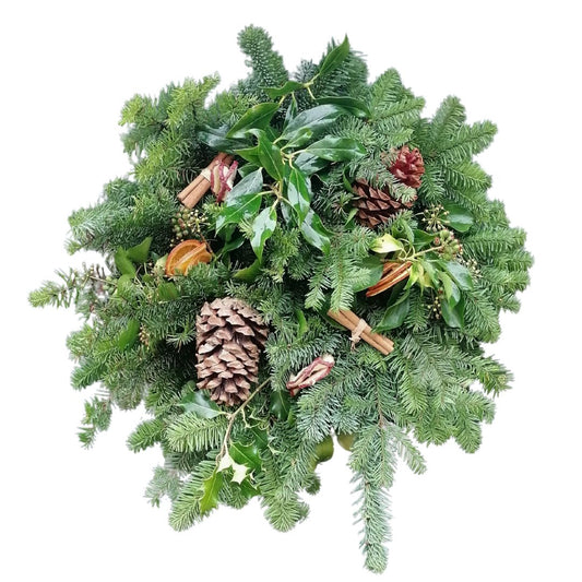 Christmas wreath with greenery, pine cones, and cinnamon sticks on a white background