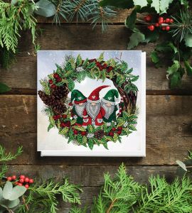 Christmas crystal art card on a wooden background with foliage adn berries surrounding it