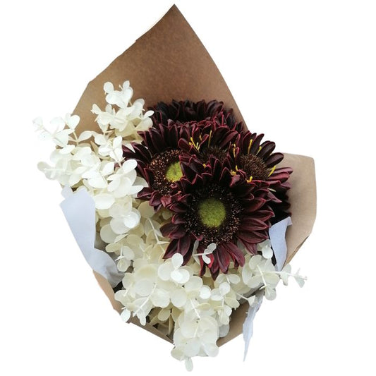 Bouquet of flowers wrapped in brown paper with white ribbon on a white background