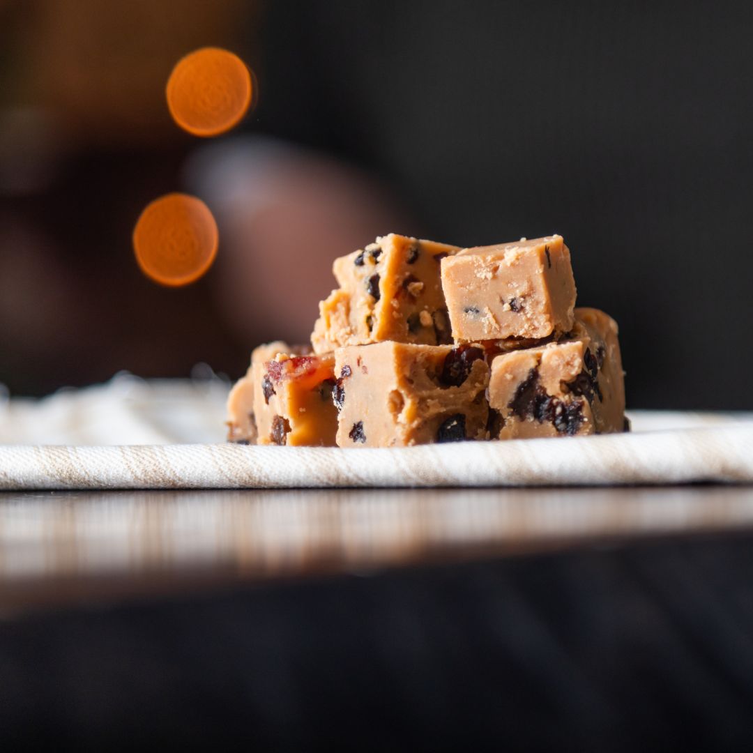 Stack of winter cake fudge on a woven napkin with blurred lights in the background