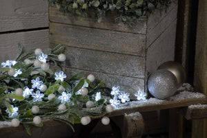 Battery snowflake Christmas lights on a pew display amongst mistletoe berries