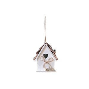 White bird house Christmas tree decoration with brow string tied in a bow in the front of the heart pop out hole