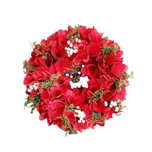 Christmas red wreath made up of red flowers, white berries and green moss
