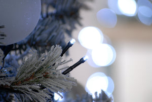 200 cold white LED string Christmas lights showing a close up of the bulbs on the decorated flocked Christmas tree