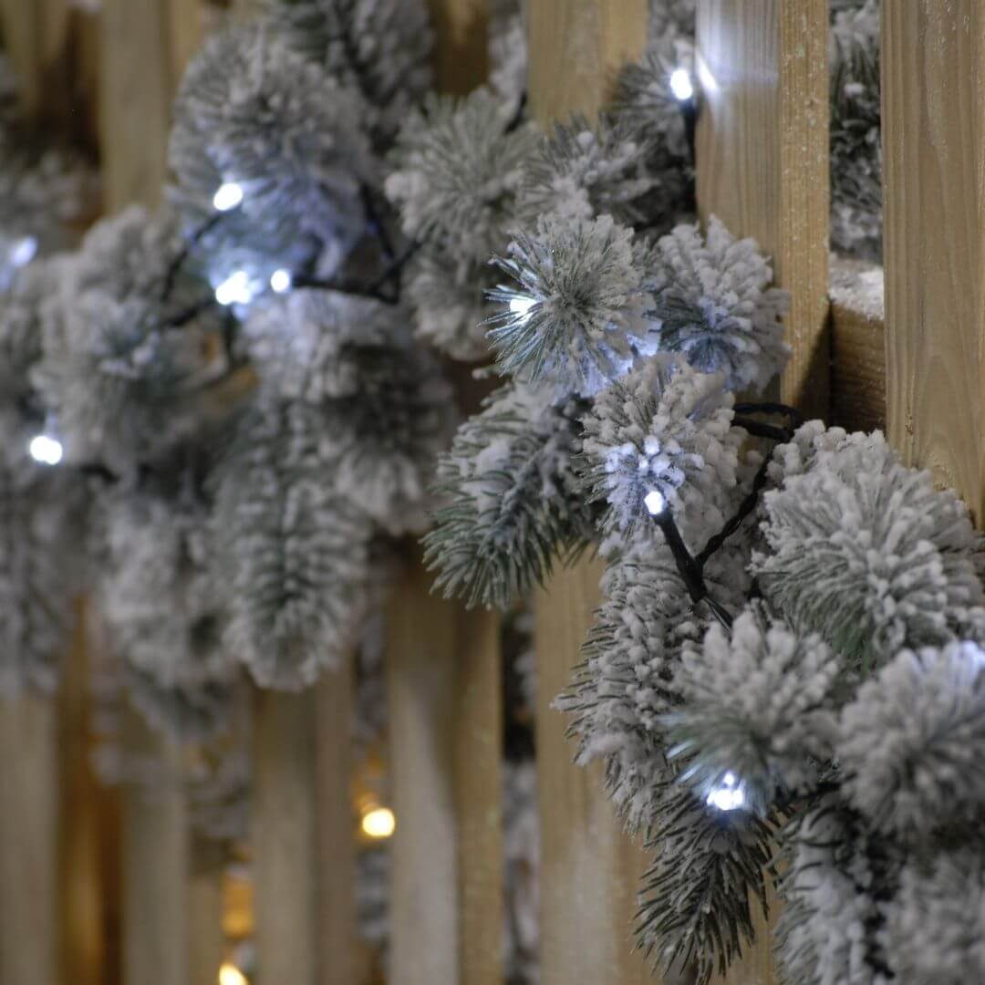 A close up of the 1000 cold white LED string Christmas lights on the fence garland
