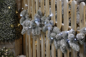 Christmas garland on fence with 360 cold white LED string Christmas lights wrapped around 