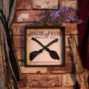 Showing the hocus pocus wooden sign on display against a red brick wall